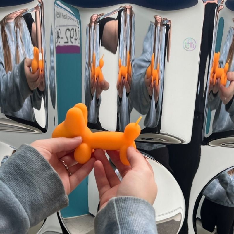 TFH Sensory Mirror With Padded Frame - Close up view with hand holding an orange balloon visible refelection