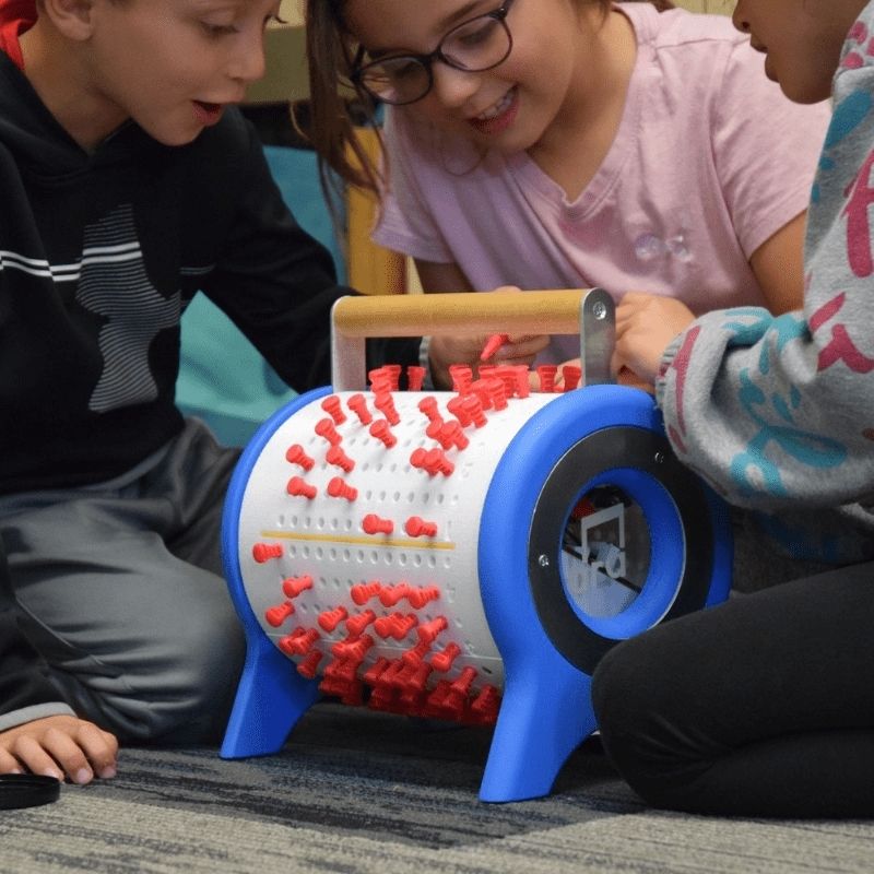 Three children actively composing and playing with Ara Musique The Ara programmable music box, demonstrating group music creation for kindergarten to grade 6 classrooms