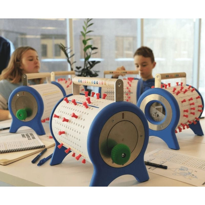 Two children engaged in music creation with Ara Musique The Ara, demonstrating the hands-on programmable cylinder music box in a classroom or therapy setting
