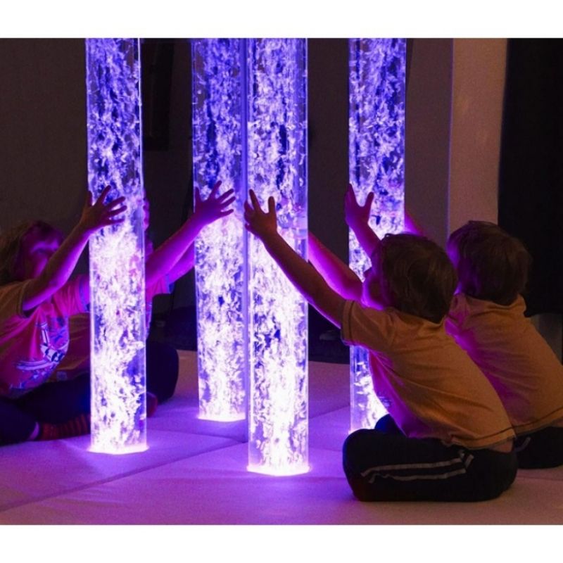 Child engaging with the Experia Calming Sensory Room bubble tube and acrylic mirror pair, showing the multiplied visual effect of the calming bubble tube in a school or therapy corner