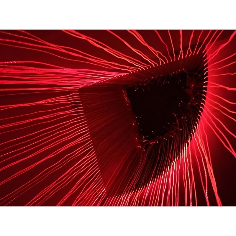 Inside view of the Experia Fibre Optic Sensory Corner Shower in red light demonstrating the safe-to-touch colour-changing fibre optic curtain surrounding a user from two sides in a sensory room corner