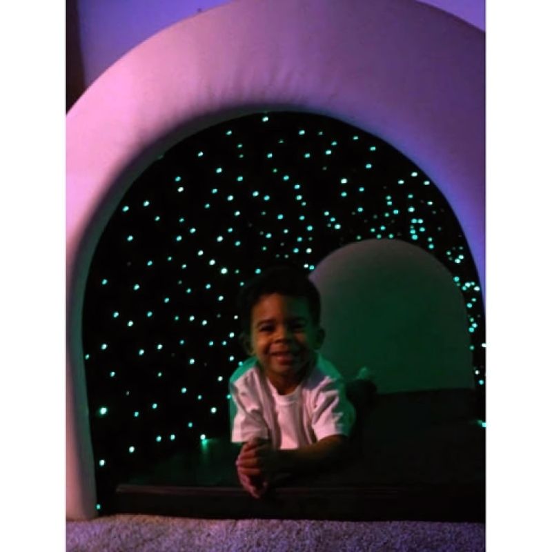 Boy crawling inside the Experia Fibre Optic Tranquility Tunnel experiencing the colour-changing fibre optic interior of the sensory hideaway tunnel