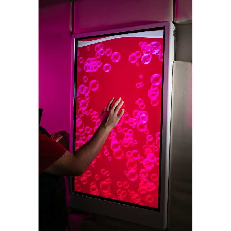 Child touching the Experia Intelli Panel Bubble Wall interactive sensory wall panel displaying red light