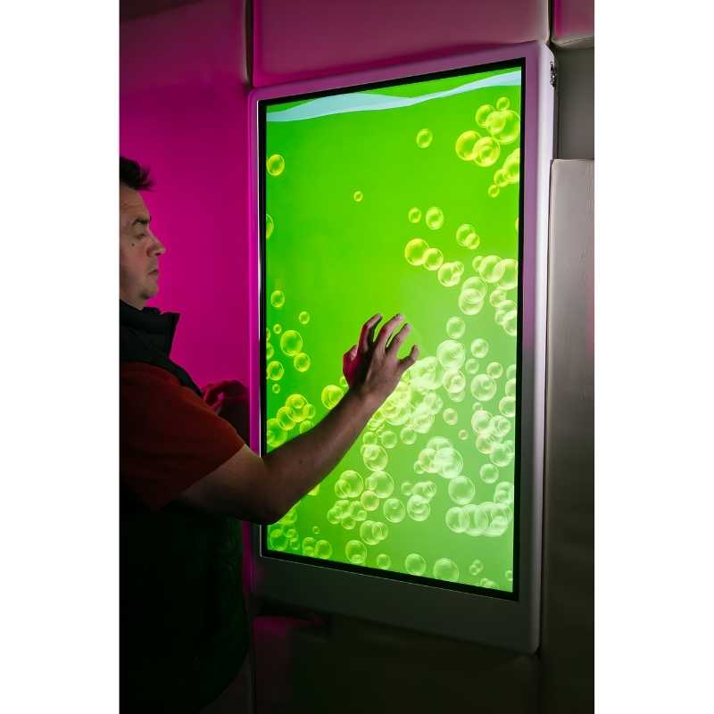 Teen engaging with the Experia Intelli Panel Bubble Wall touchscreen sensory panel displaying green light