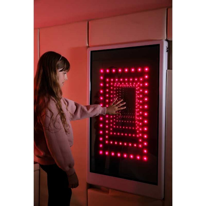 Teen engaging with the Experia Intelli Panel Infinity touchscreen sensory wall panel in red light