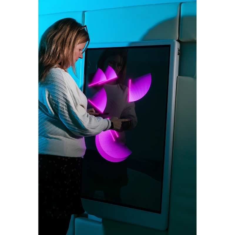 Adult engaging with the Experia Intelli Panel Musical Touch interactive sensory wall panel displaying pink light