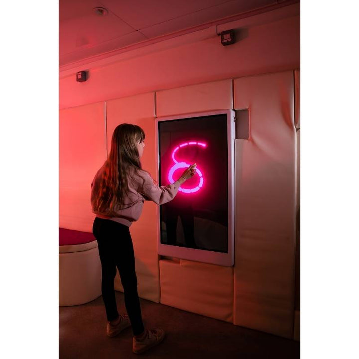 Adult engaging with the Experia Intelli Panel Musical Touch touchscreen sensory wall panel in a red-lit therapy room