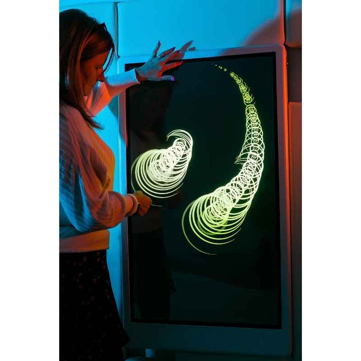 Adult engaging with the Experia Intelli Panel Musical Touch interactive sensory panel displaying a spiral green light effect