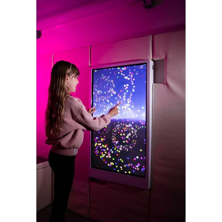 Child engaging with the Experia Intelli Panel Particle interactive sensory wall panel in multicolour display mode