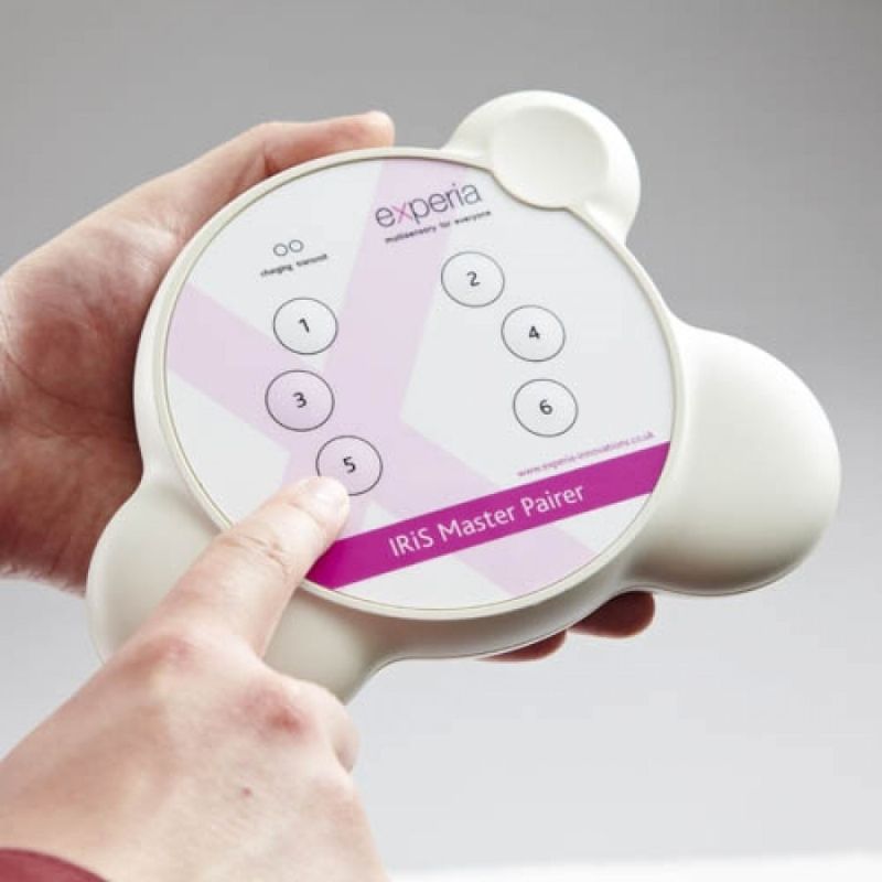 Close-up of the Experia IRiS Master Pairer with an active button press, demonstrating the single-button re-pairing of any IRiS Listener to any Talker without accessing each device