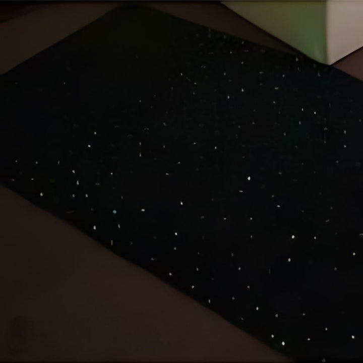 Landscape view of the Experia LED Fibre Optic Star Carpet showing the full 2m x 1m black carpet surface with colour-changing fibre optic lights creating a galaxy star-field effect
