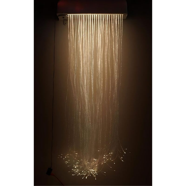 Experia LED Fibre Optic Wall Cascade front view in warm light showing the full 150-strand colour-changing fibre optic curtain cascading from the swiveling wall-mounted bracket