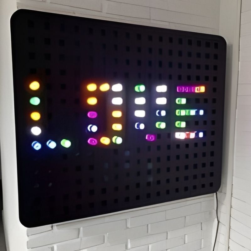 Experia PixelPop Interactive Light Panel displaying a word or pattern design made with coloured glowing pegs, showing the creative peg board activity for sensory rooms and classrooms