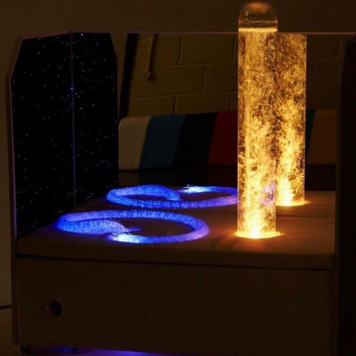Experia Portable Sensory Corner Calming with orange LED bubble tube and blue-purple fibre optic strands glowing, demonstrating the colour-cycling calming sensory light effect