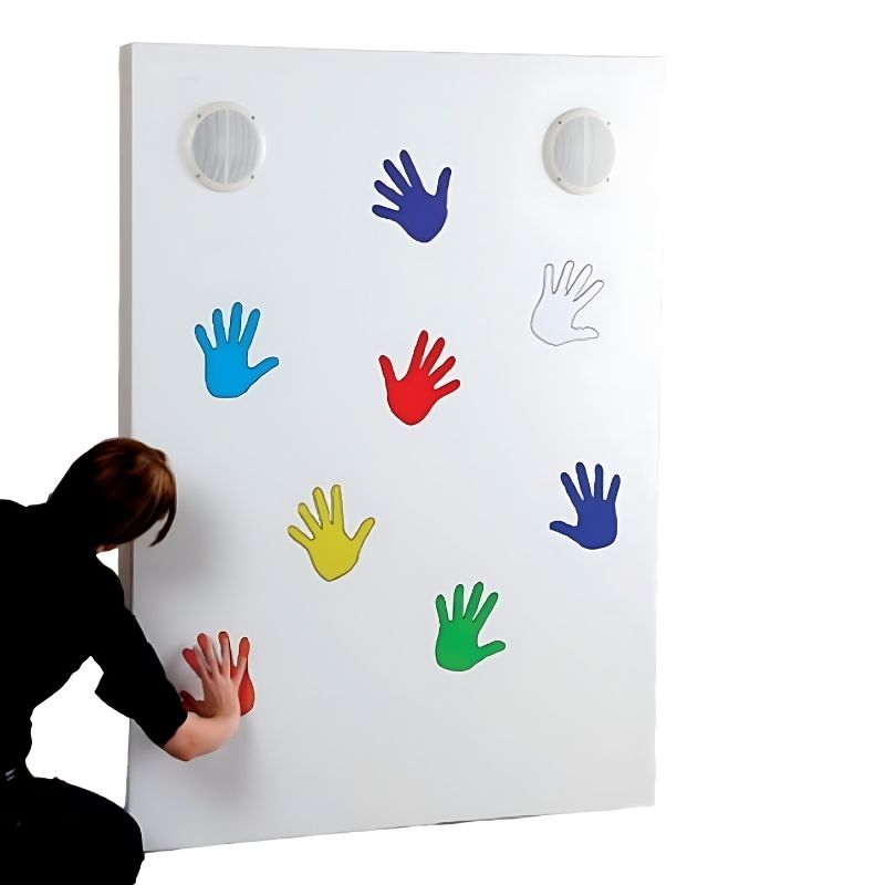 Adult touching one of the eight coloured hand shapes on the Experia Sound Wall, demonstrating the touch-activated music making and cause-and-effect interaction of the interactive sensory music panel