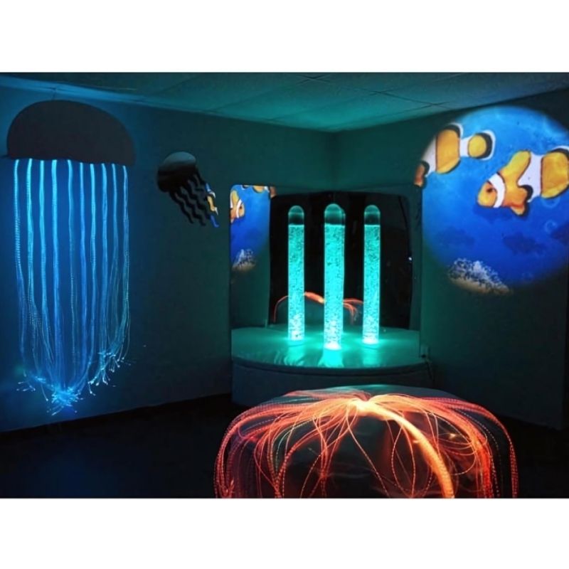 Experia Calming Underwater Adventure Room landscape view with bubble tube in green light, demonstrating the automatic colour cycling of the calming sensory room bundle