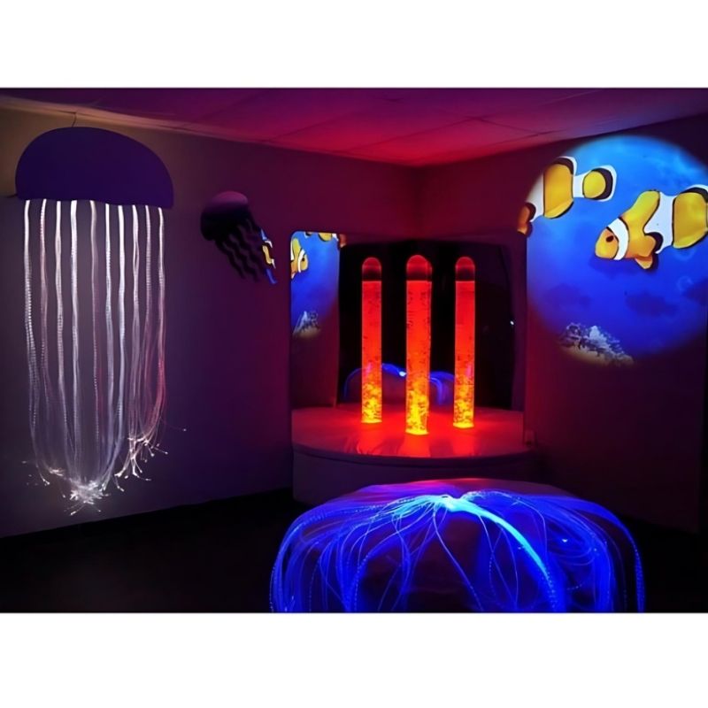 Experia Calming Underwater Adventure Room landscape view with bubble tube glowing in red light, showing the colour-cycling calming sensory environment