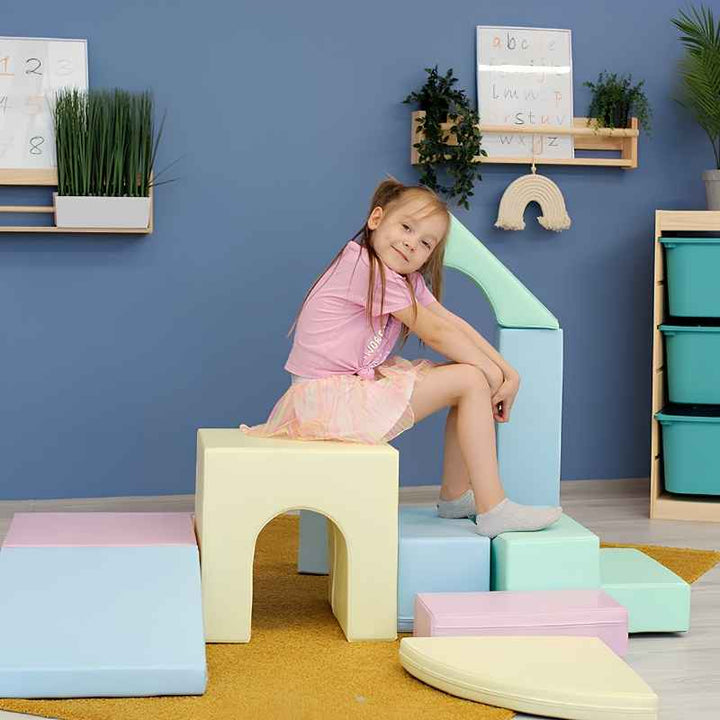 A young girl sitting on the IGLU Foam Play Set Creativity in Light Pastel during quiet sensory play