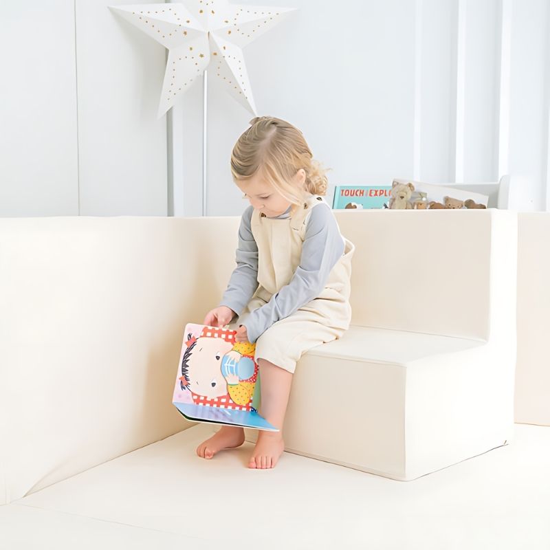 Child reading a book inside the Ggumbi Lucky Star Clean Bumper Play Room Extra Large Ivory, showing the versatile enclosed play and relaxation space for babies and toddlers