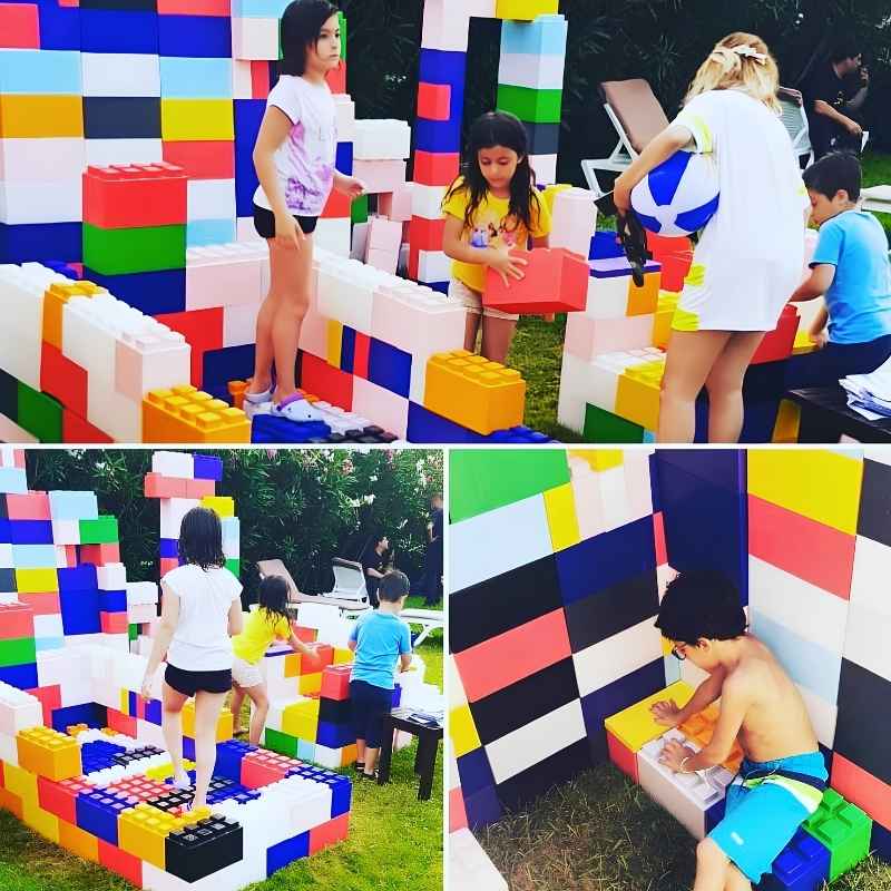 Children building a colourful fort with giant EverBlock building blocks during an outdoor STEM play session