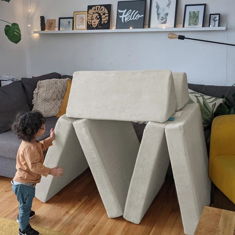 Child actively playing on Go Coconut - The Coconut in Poppy Pop demonstrating the gross motor development, proprioceptive input, and creative play value of the Canadian-made modular foam play couch