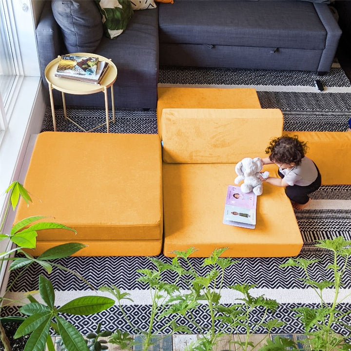 Top-down view of a child playing on the Go Coconut Half Coconut modular foam play couch, supporting proprioceptive and motor development