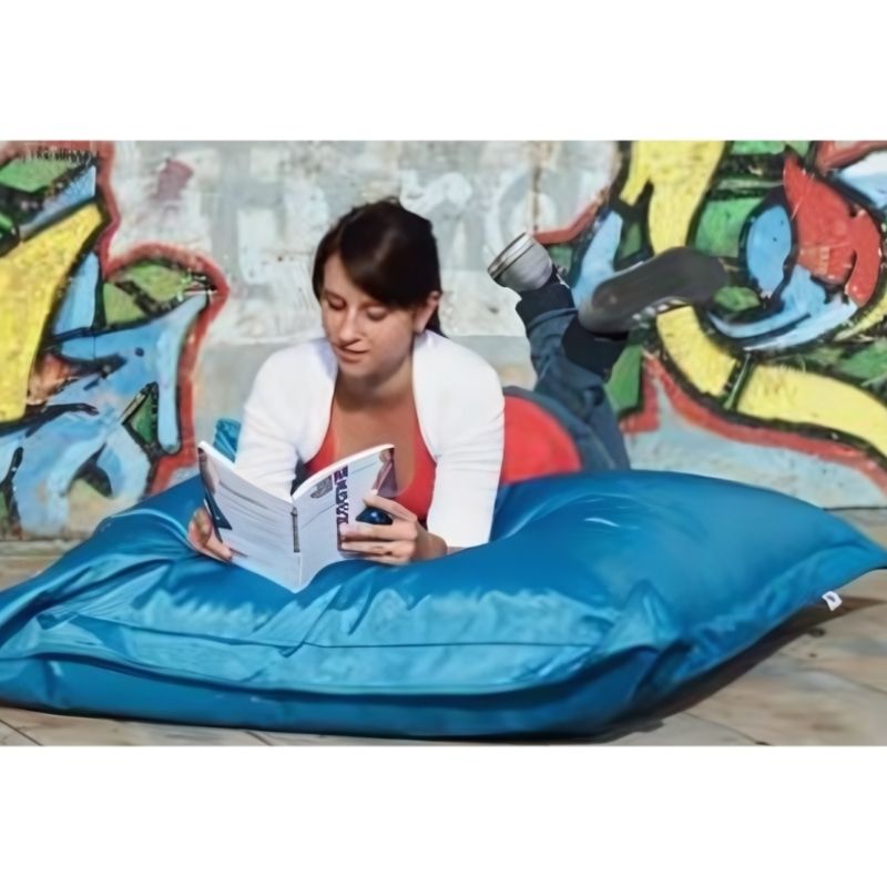 Adult reading on the HABA Pro Turquoise Bean Bag Cushion indoors, demonstrating its use as a sensory lounger and quiet corner seating option