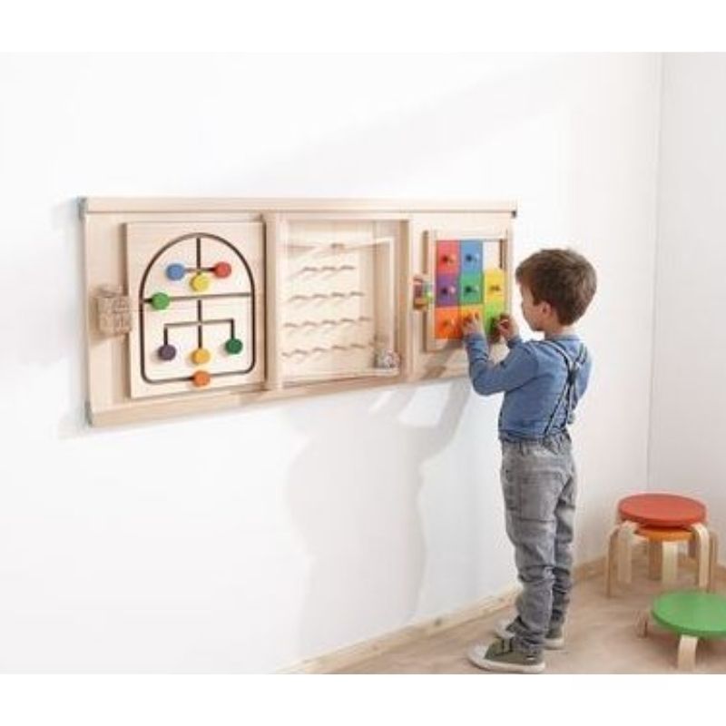 HABA Pro Colorful Squares sensory wall panel installed in an indoor classroom or therapy room with child engaged in active play