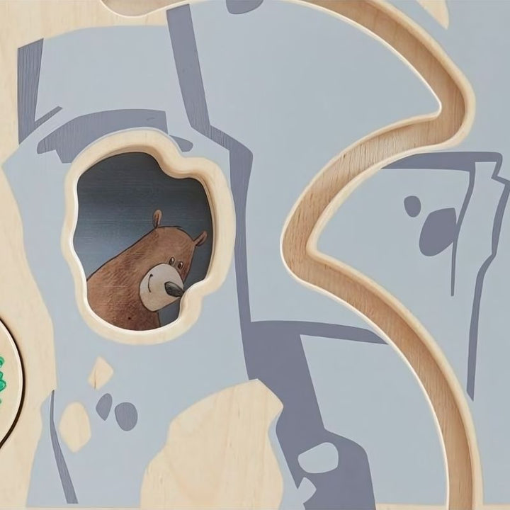 Close-up of the bear sliding element on the HABA Pro Forest Sensory Wall Panel, a hidden creature revealed through cause-and-effect play