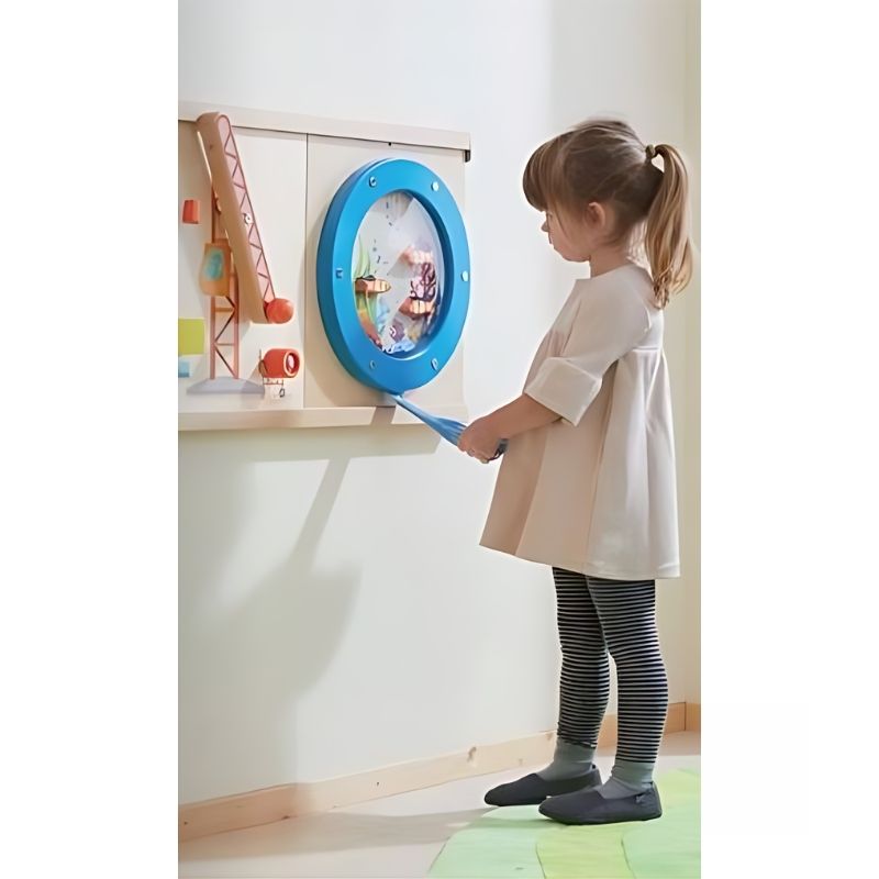Young girl interacting with the HABA Pro Ocean Sensory Wall Panel, exploring the interactive activity wall panel in a home or therapy room setting
