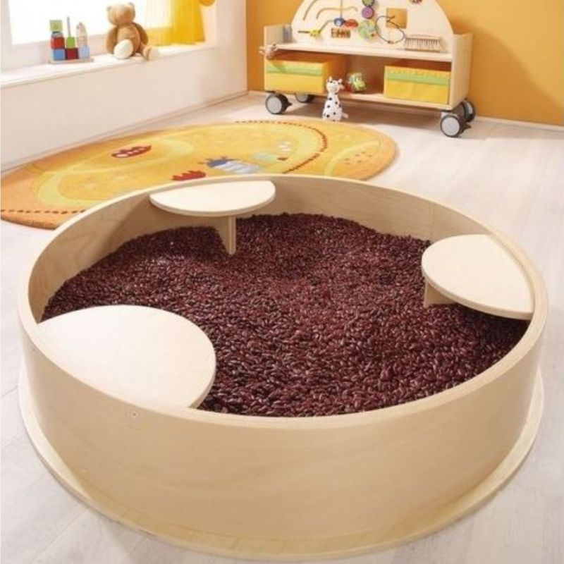 HABA Pro Sensory Bath with Lid - round wooden tactile play basin with lid on, shown as a sit-and-play area for children