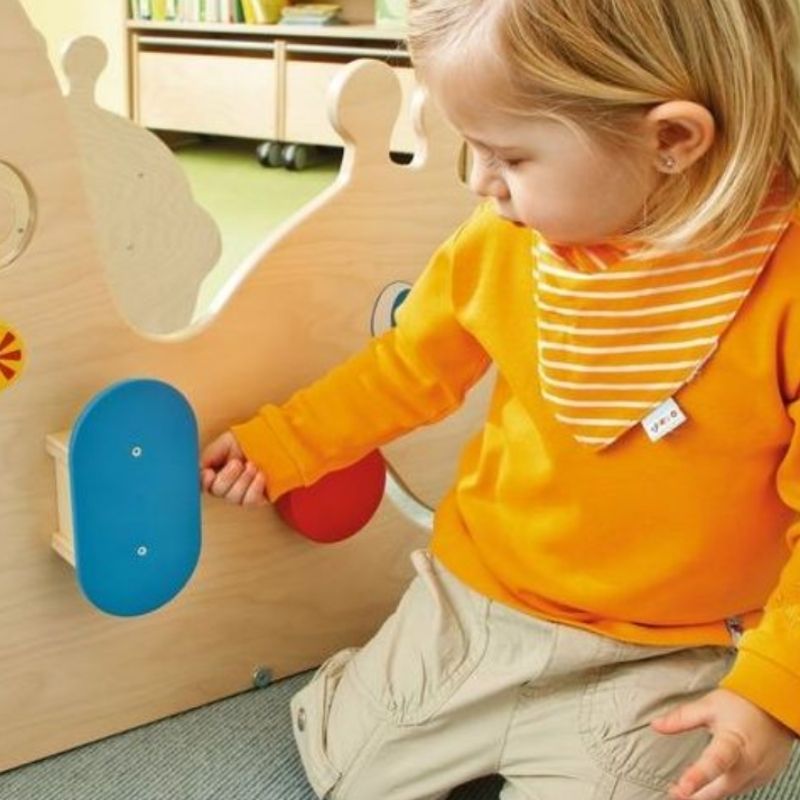 HABA Pro Discovery Snail fabric body showing brushes, tactile bag, fabric strips with sewn-in sensory elements, and squeakers that encourage auditory and tactile exploration in young children