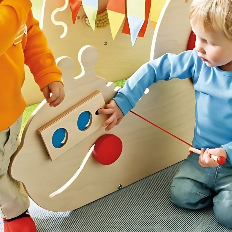 HABA Pro Toddler Sensory Activity Discovery Snail shown in a daycare or therapy room setting, illustrating the scale and floor-standing format of this commercial-grade wooden sensory toy