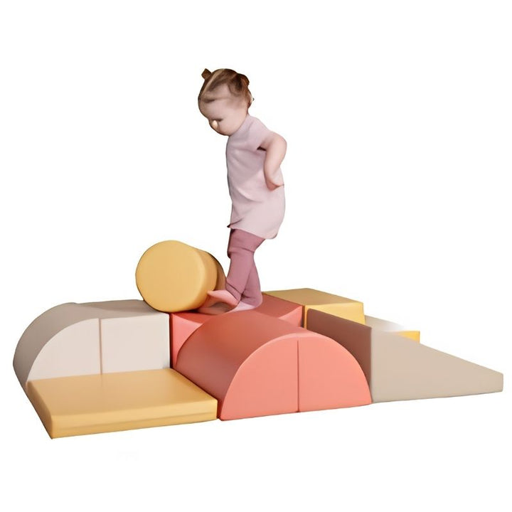 Toddler climbing over the cylinder piece on the IGLU Adventurer Soft Play Set in Pastel Pink during active play