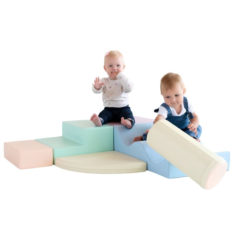 Two babies playing on the IGLU Explorer Soft Play Set in a pastel colourway, climbing the step and rolling the foam cylinder