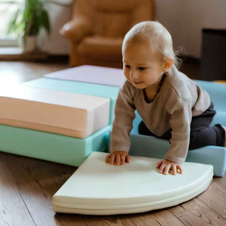 Toddler crawling toward the IGLU Explorer Soft Play Set's quarter-round foam shape in a home living room