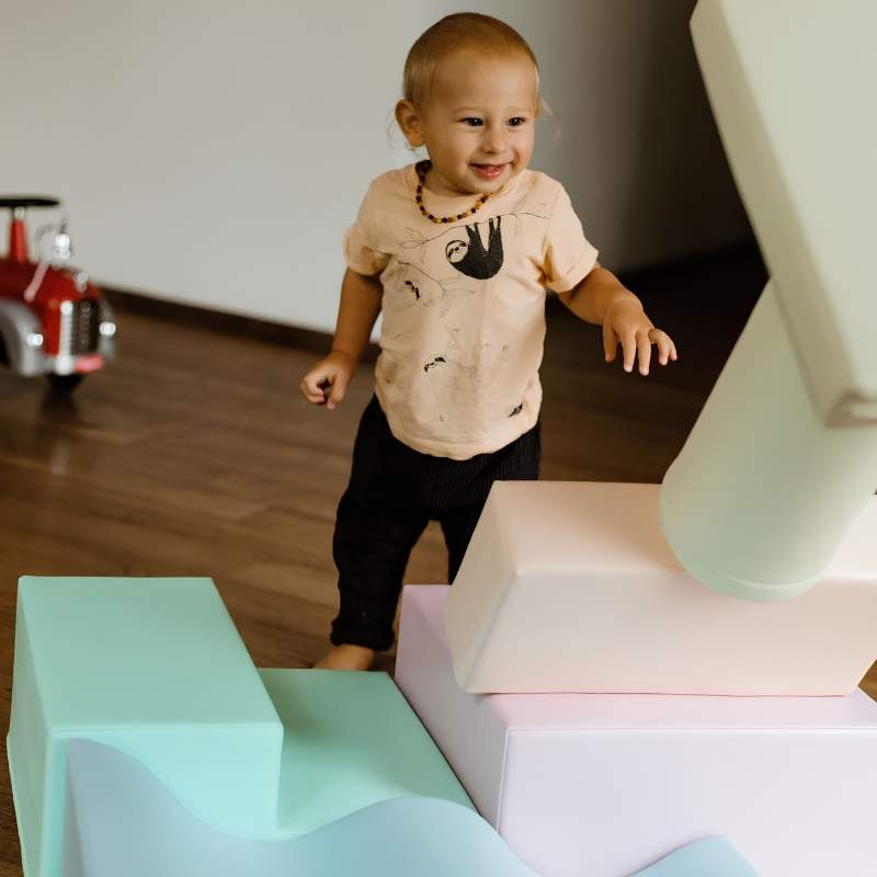 Toddler walking toward the IGLU Explorer Soft Play Set foam shapes in a pastel colourway