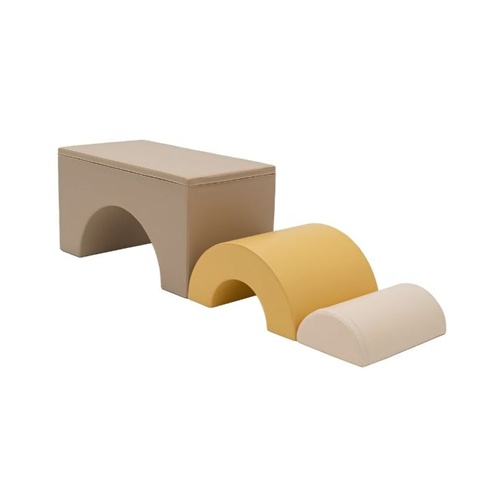 IGLU Rainbow Bridge Soft Play Set Beige/Honey colourway arranged as a toddler obstacle course, with the large beige bridge, medium yellow arch, and small cream dome positioned in a descending sequence