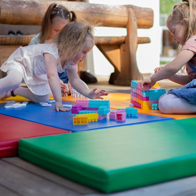 IGLU Safety and Comfort 5 Mat Set in Multi-Colour arrangement with three children engaged in active soft play on cushioned foam mats