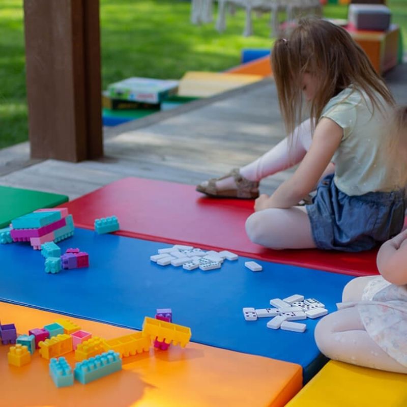 Two children playing on the IGLU Safety and Comfort 5 Mat Set, demonstrating active gross motor play on foam soft play mats