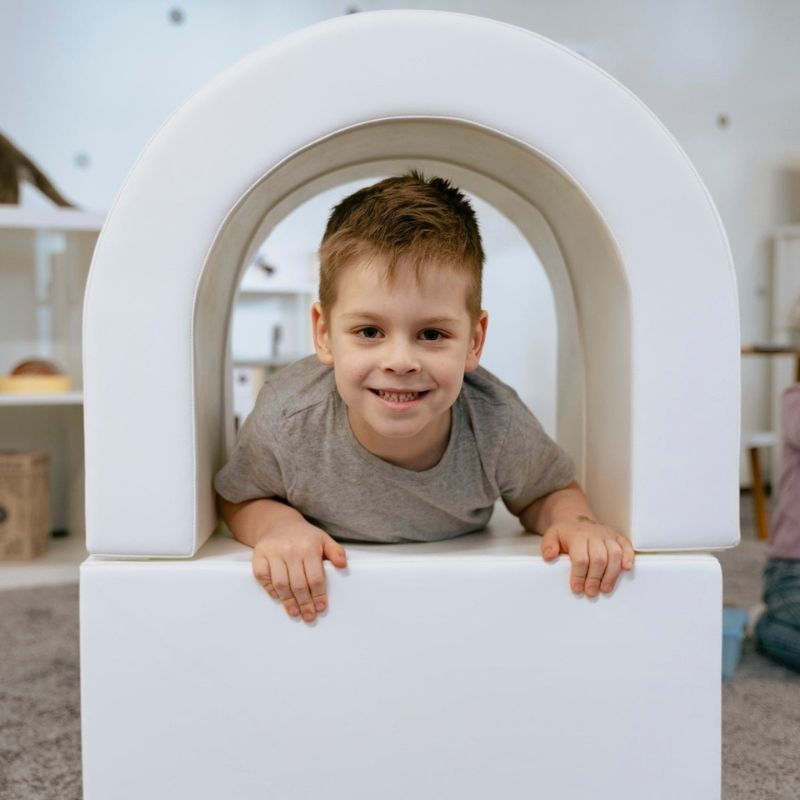 Toddler crawling through the IGLU Soft Play Imagination Tunnel, developing gross motor skills and vestibular awareness through active indoor play