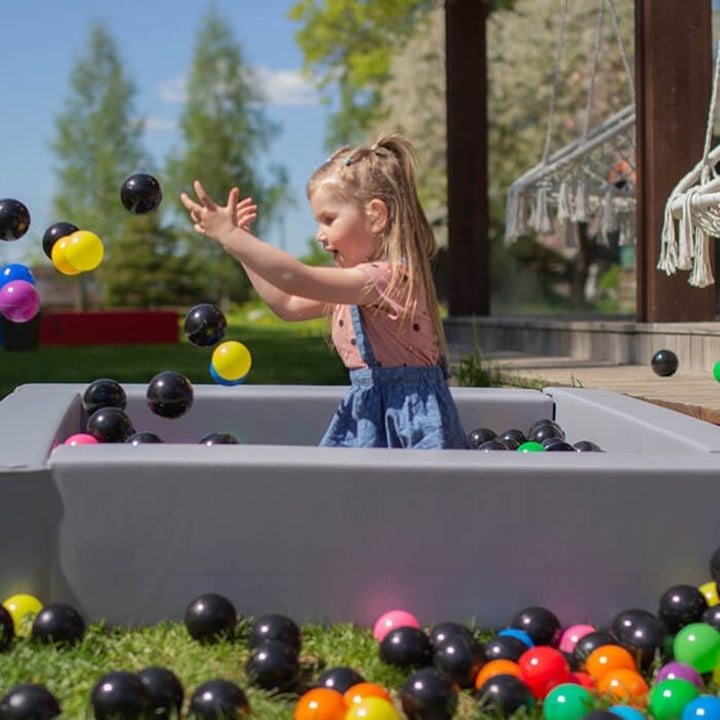 Child playing in IGLU Soft Play Square Ball Pit in grey, a foam ball pit for toddlers suitable for home and therapy room use