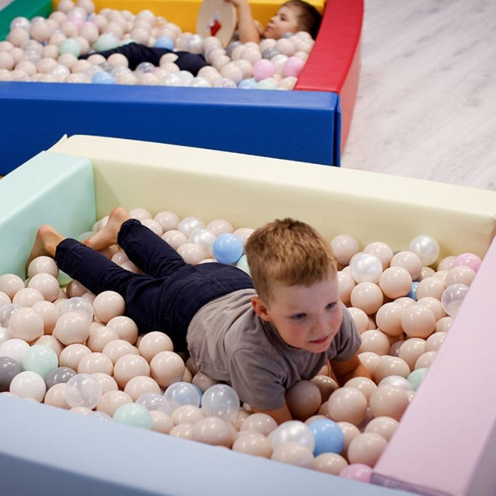Child playing in IGLU Soft Play Square Ball Pit in light pastel colour, a foam ball pit ideal for toddler sensory development