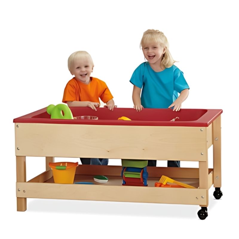 Child actively playing at the Jonti-Craft Toddler Sensory Table with Shelf 20" High showing the Baltic Birch frame, toddler standing height, and sensory tub with drain and valve