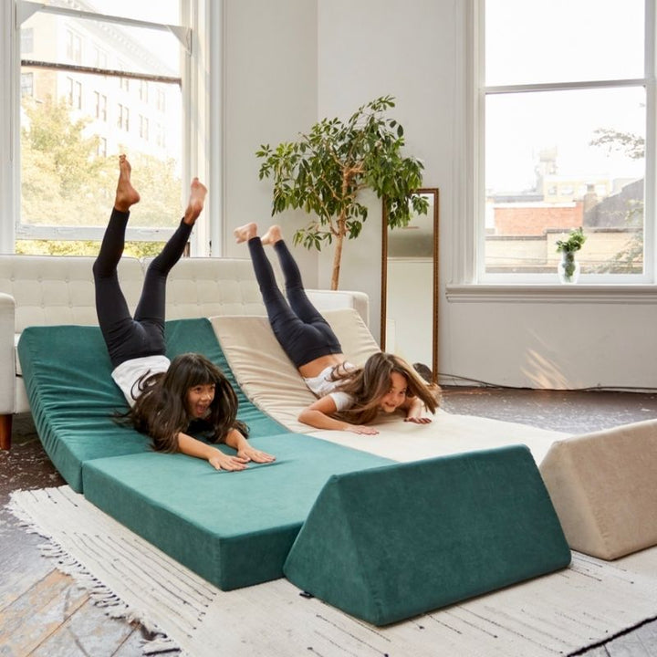 Children building a fort with the Kiddie Couch modular play couch in Green and Beige, encouraging imaginative and collaborative play
