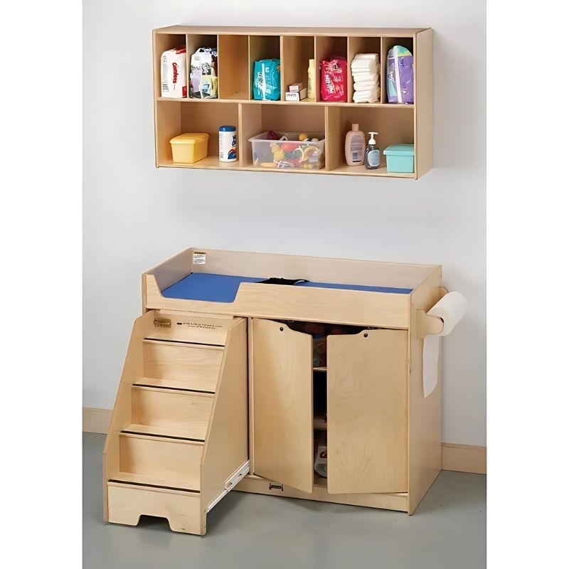 Kinderhuis Change Table with Stairs showing pull-out stair design and three open storage shelves, a Montessori toddler changing station for daycares and family homes