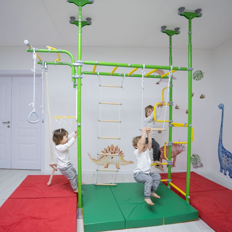 Children playing on the LimiKids Pegasus indoor playset, portrait view showing active climbing and swinging on the pressure-mounted Canadian-made indoor jungle gym with monkey bars