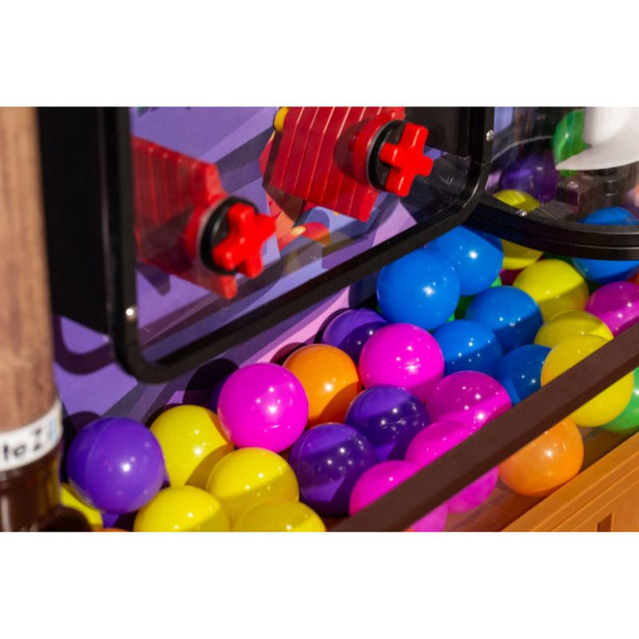 Close-up of the colourful ball collection tray and launch mechanism on the LiteZilla Ultimate Ball Launcher, showing the multicolour balls used in this air-powered sensory exhibit