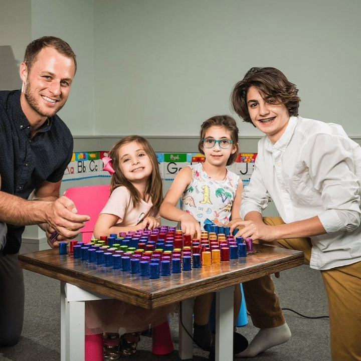 Family members playing together with the LiteZilla Mini lite brite, showing its versatility for home sensory play