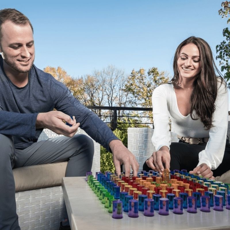 Two adults engaging with the LiteZilla Mini interactive light board in an outdoor setting